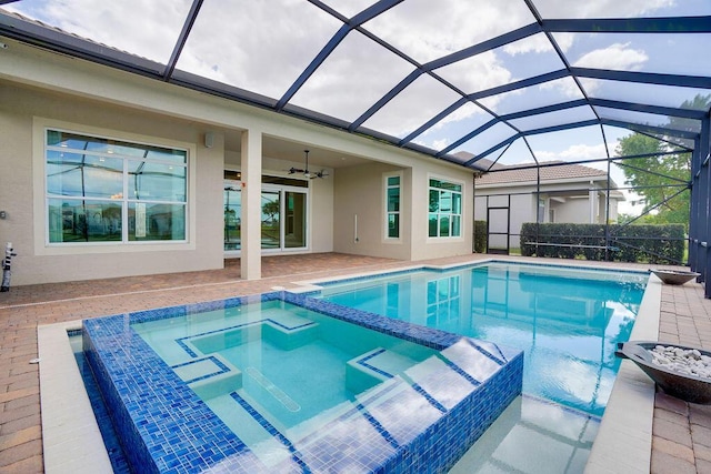 view of pool featuring an in ground hot tub, ceiling fan, a lanai, and a patio area