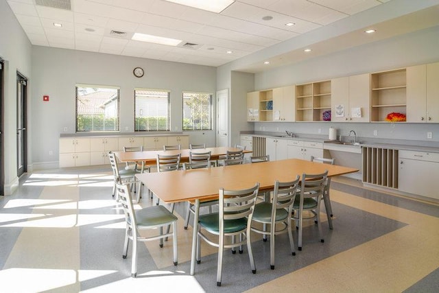 dining space featuring a paneled ceiling and sink