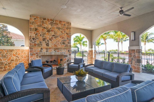 view of patio featuring ceiling fan and an outdoor living space with a fireplace