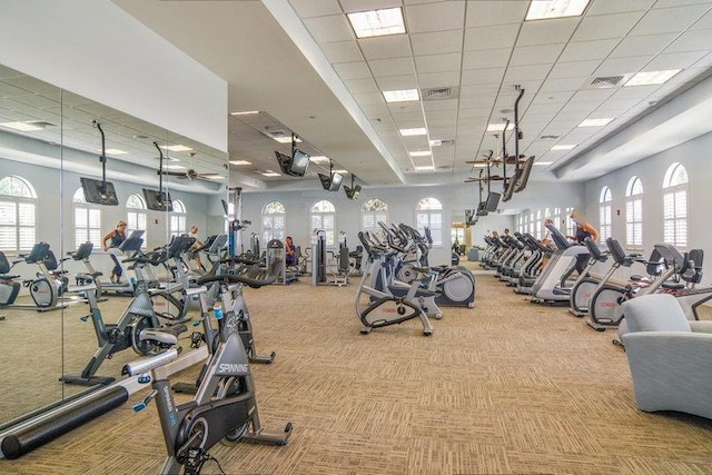 exercise room featuring light carpet and a paneled ceiling