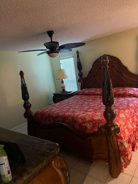 bedroom with light tile floors, a textured ceiling, and ceiling fan