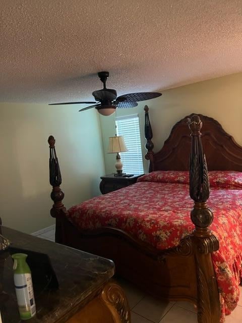 tiled bedroom with a textured ceiling and ceiling fan