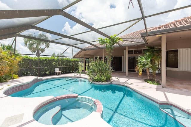 view of swimming pool featuring an in ground hot tub, a lanai, and a patio area