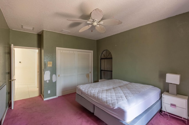 carpeted bedroom featuring ceiling fan, a textured ceiling, and a closet