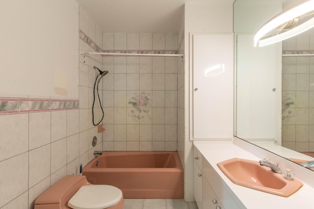 full bathroom featuring tiled shower / bath, tile walls, tile patterned flooring, vanity, and toilet