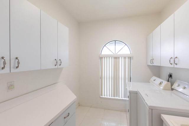 washroom with cabinets, washer and dryer, and light tile patterned floors