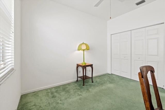 interior space featuring dark carpet and ceiling fan