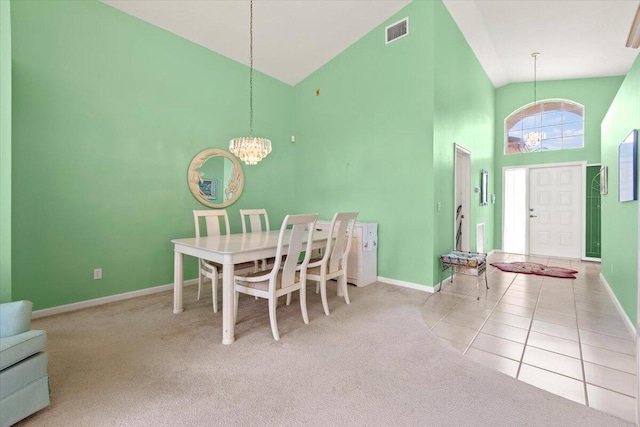 dining space with light carpet, high vaulted ceiling, and an inviting chandelier