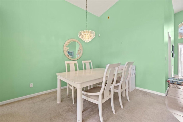 carpeted dining room with high vaulted ceiling and an inviting chandelier