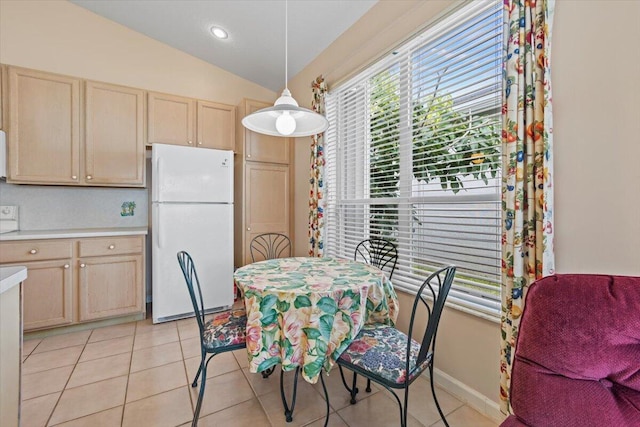 tiled dining space with vaulted ceiling