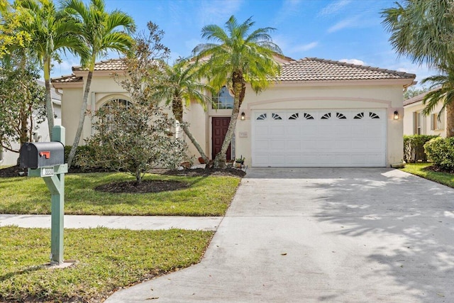 mediterranean / spanish-style house featuring a front yard and a garage