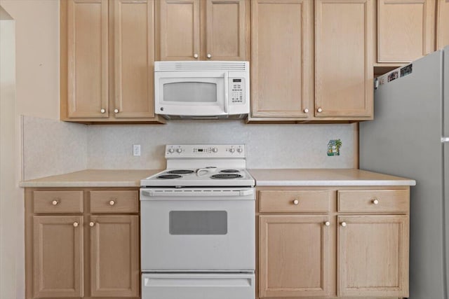 kitchen featuring white appliances and light brown cabinetry