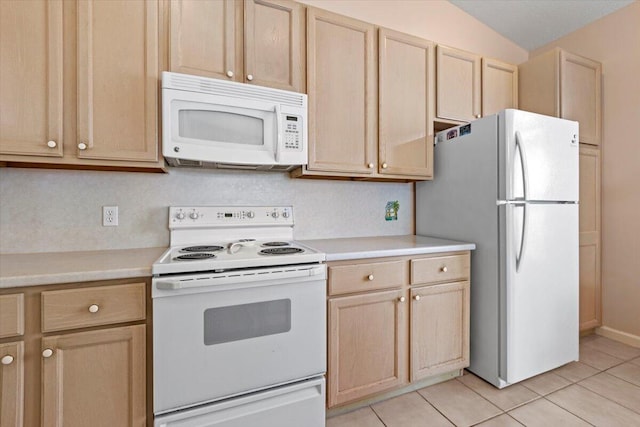 kitchen with lofted ceiling, light tile floors, light brown cabinets, and white appliances