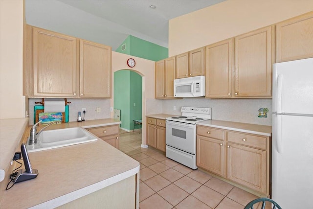 kitchen featuring light brown cabinets, white appliances, and sink