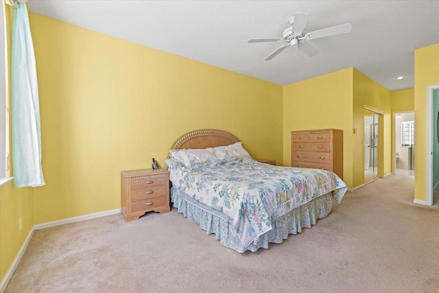 carpeted bedroom with a closet, ensuite bath, and ceiling fan