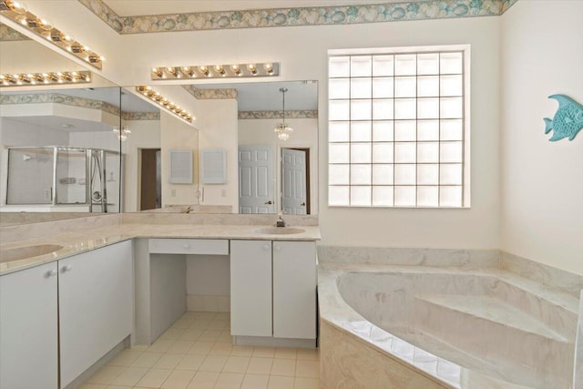 bathroom featuring plenty of natural light, tiled bath, and dual bowl vanity