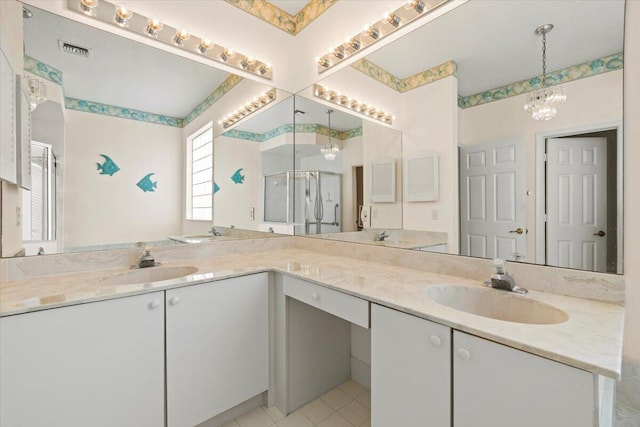 bathroom featuring tile floors, large vanity, double sink, and an inviting chandelier