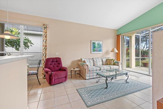 living room with a healthy amount of sunlight, vaulted ceiling, and light tile floors