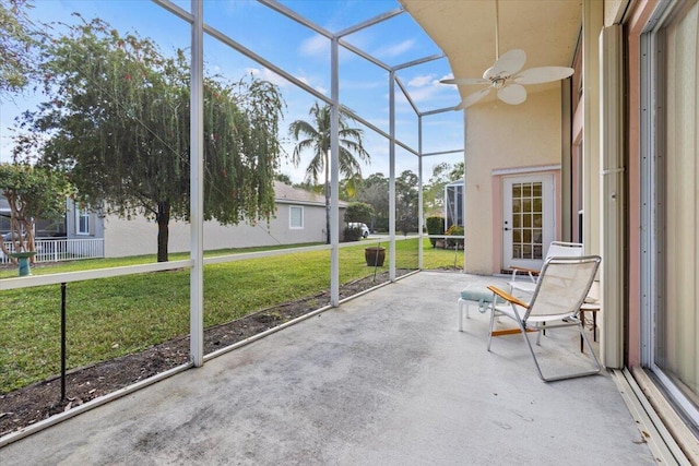 unfurnished sunroom featuring ceiling fan