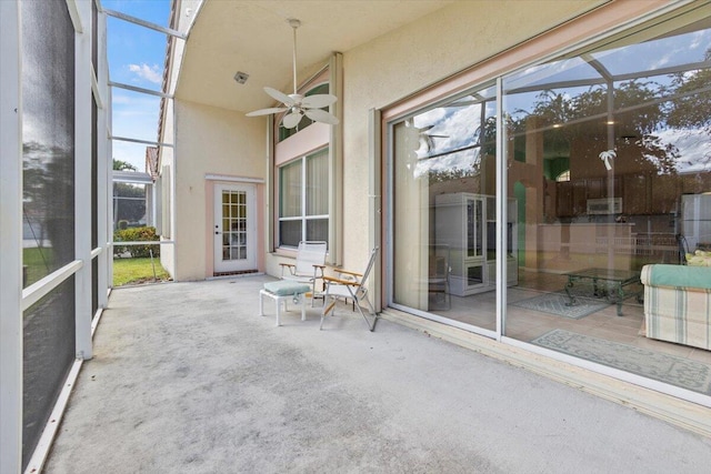 unfurnished sunroom featuring ceiling fan