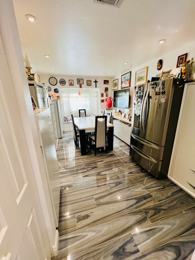 tiled dining area featuring a textured ceiling