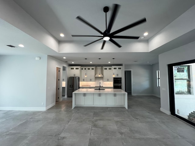 kitchen with ceiling fan, sink, premium range hood, stainless steel appliances, and white cabinets