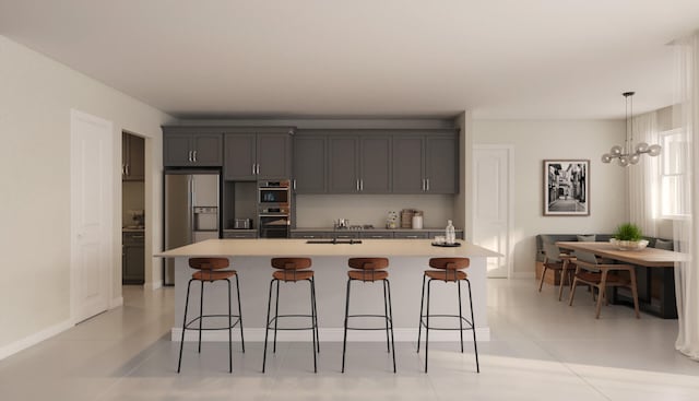 kitchen with a chandelier, an island with sink, pendant lighting, light tile floors, and a breakfast bar