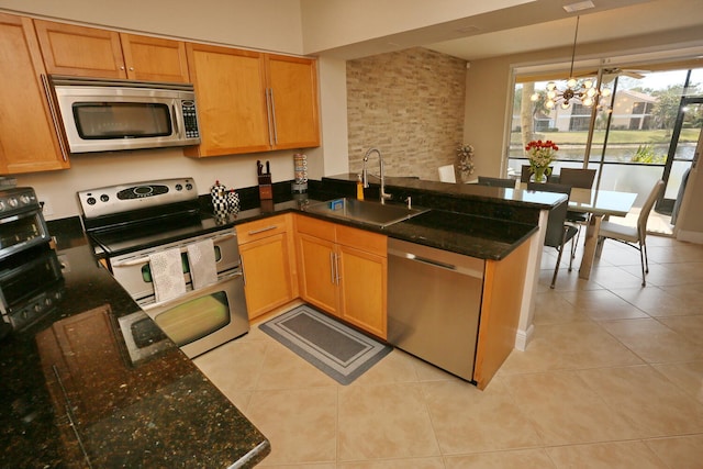 kitchen with light tile flooring, sink, appliances with stainless steel finishes, and an inviting chandelier