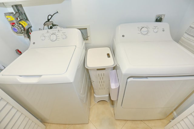 laundry area featuring washer hookup, electric dryer hookup, separate washer and dryer, and light tile floors