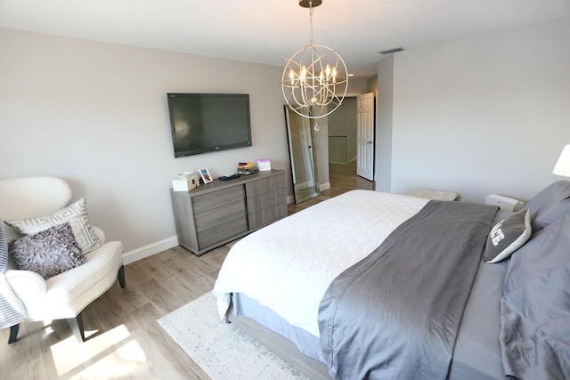 bedroom with light hardwood / wood-style flooring and a notable chandelier