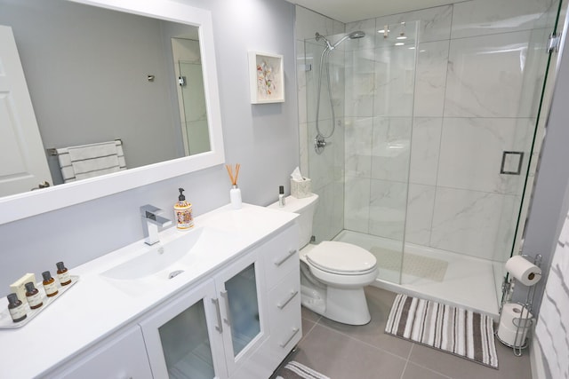 bathroom featuring vanity, tile flooring, toilet, and walk in shower