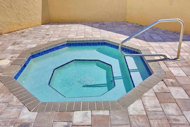 view of swimming pool featuring an in ground hot tub and a patio