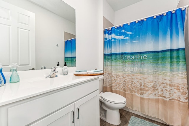 bathroom with tile floors, large vanity, and toilet