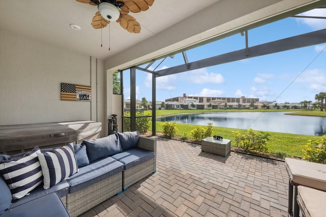 sunroom / solarium featuring ceiling fan and a water view