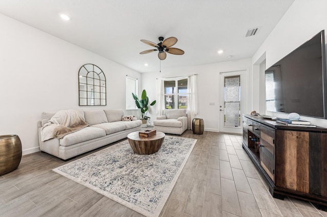 living room featuring ceiling fan and light hardwood / wood-style flooring