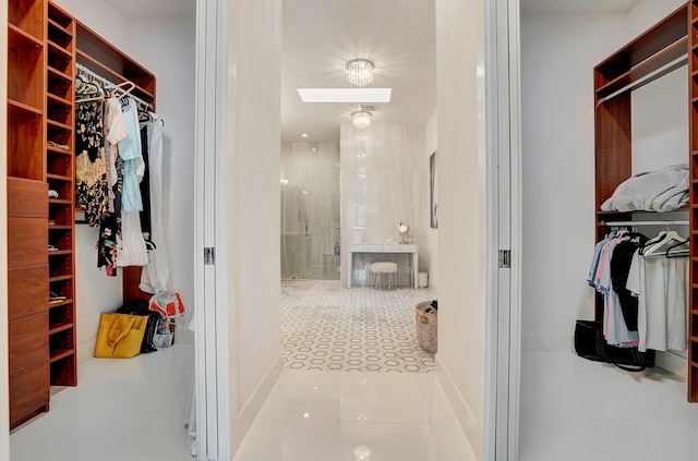 walk in closet with light tile patterned floors