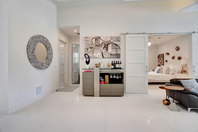 bar with a barn door and tile patterned floors