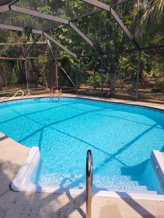 view of pool featuring glass enclosure