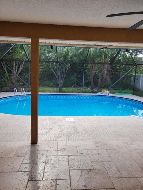 view of swimming pool with a patio and a lanai