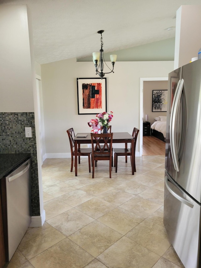 tiled dining area with a chandelier and lofted ceiling