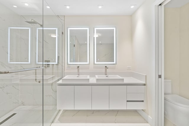 bathroom featuring toilet, a shower with door, dual vanity, and tile flooring