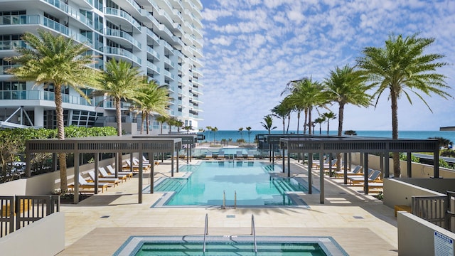 view of swimming pool featuring a community hot tub and a water view