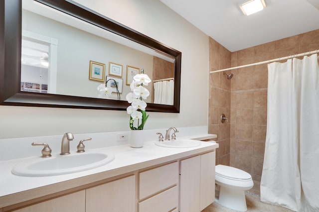 bathroom featuring toilet, ceiling fan, dual vanity, and tile flooring