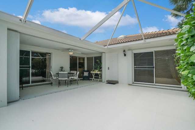 exterior space with glass enclosure and ceiling fan