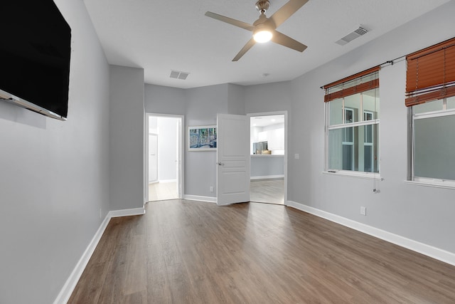 unfurnished living room with ceiling fan and hardwood / wood-style floors