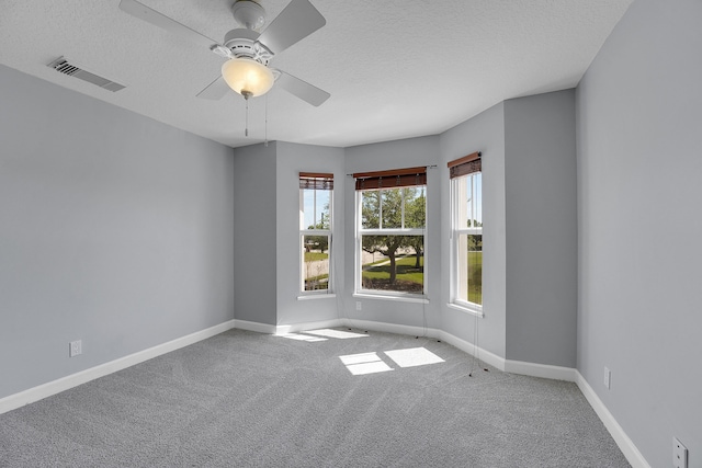 unfurnished room with carpet floors, ceiling fan, and a textured ceiling