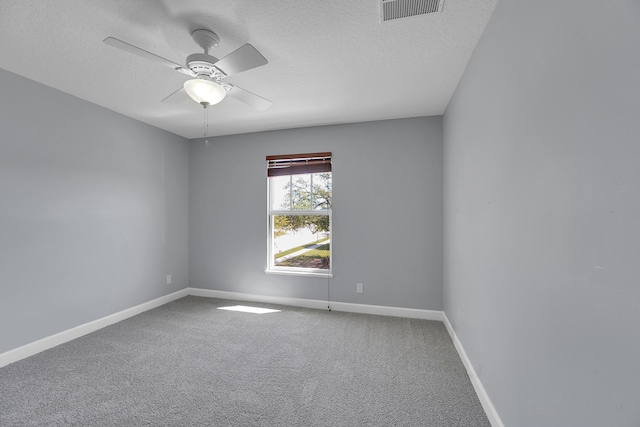 carpeted empty room with ceiling fan and a textured ceiling