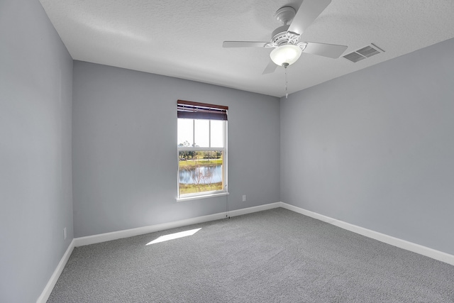 carpeted spare room featuring ceiling fan and a textured ceiling