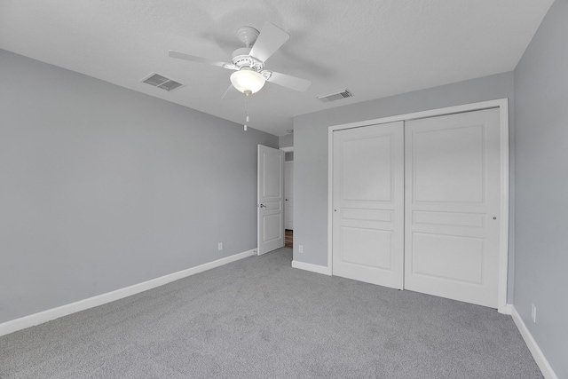 unfurnished bedroom featuring carpet flooring, ceiling fan, and a closet