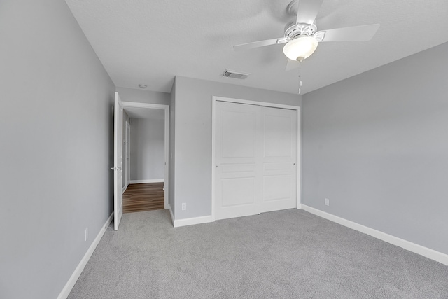 unfurnished bedroom with carpet, a closet, and ceiling fan